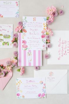 the wedding stationery is laid out with pink flowers