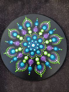 a circular painting on the ground with dots and circles painted on it's surface