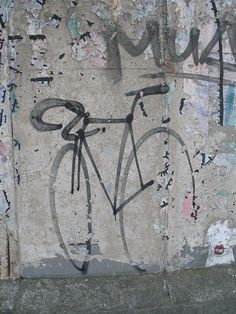 graffiti on the side of a wall with a bicycle