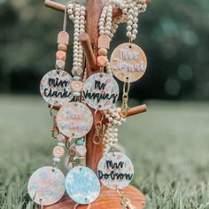 a wooden stand with many different necklaces hanging from it's sides in the grass