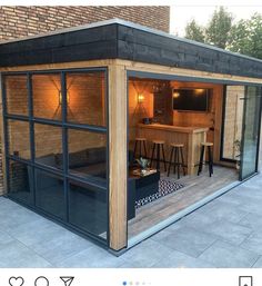 a small wooden building with glass doors and windows