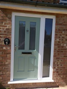 the front door to a brick building with a white frame and glass pane on it