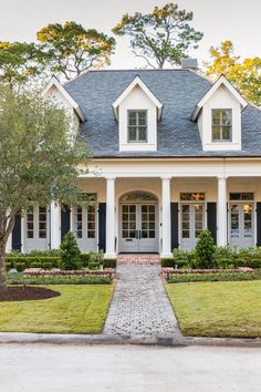 a white house with black shutters and trees