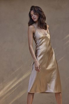 The Silky Satin Midi is the slip dress of your dreams. Featuring a seamed bust and v-neckline that references vintage silk slip styling, seamlessly contrasted against a modern midi length. The satin shoulder straps cross at the back, lending a sophisticated accent to its simplicity. Paying homage to the mesmerising glow of Marrakesh, this golden hue embodies gilded glamourWhilst we aim to ensure that every image accurately depicts the true colour, please consider that our colours can vary slight Gold Dress Wedding Guest, Nude Silk Dress, Gold Bridesmaid Dress, Wedding Gown Trends, Dress Satin Bridesmaid, Gold Bridesmaid Dresses, Designer Bridesmaid Dresses, Occasion Wear Dresses, Perfect Bridesmaid Dress