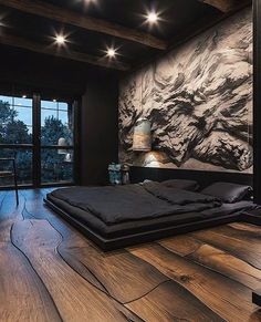 a bedroom with wood flooring and large painting on the wall next to it's bed