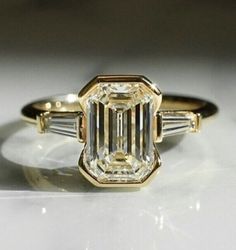 an engagement ring with three baguets on the side and two diamonds in the middle