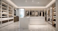 a walk in closet with white shelves and drawers