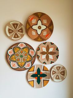 four woven coasters are arranged on the wall