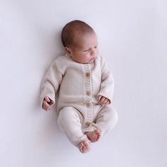 Bundle up your little one in style with our Long Sleeve Baby Knitted Announcement Romper, perfect for winter. Crafted from high-quality cotton, this romper ensures maximum comfort and durability. Its long sleeves and legs provide extra warmth, making it ideal for chilly weather. Designed to be an heirloom piece, our romper showcases a timeless knit pattern that adds an elegant touch. Its gender-neutral design makes it versatile for any baby, while its soft fabric keeps them cozy and comfortable all day long. Not only is this romper a practical choice, but it also serves as a delightful photography prop for capturing those precious moments. Whether you're planning a newborn photoshoot or announcing the arrival of your little one, this romper will make them look irresistibly adorable. Our Lo Winter Knitted Long Sleeve Onesie, Cream Long Sleeve Cotton Jumpsuit, Beige Long Sleeve Onesie For Playtime, Cream Cotton Onesie For Winter, Winter Cream Cotton Onesie, Cream Long Sleeve Onesie For Winter, Fall Cream Cotton Onesie, Cute White Jumpsuits And Rompers For Fall, Announcement Outfit