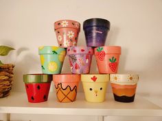 there are many colorful cups on the shelf