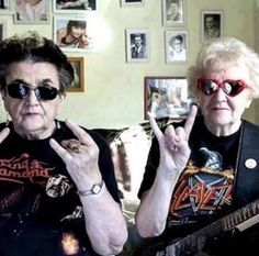 two women sitting next to each other with their fingers in the shape of peace signs