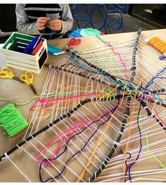 a table topped with lots of different colored yarns and scissors on top of it