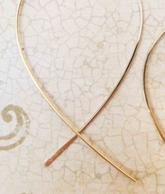 Lightweight loop cross over threader hoop earrings made of 14k gold filled wire. The unique cross over design with one end hammered makes it easy to thread through your ear using the smaller tail. Cute for everyday wear and elegant for your evening nights out too. Each hoop pictured measures 2 inches long by 1 1/2 inches wide. Fish tails extend 1/2 inch to 1 inch long. Fish threader hoops available in 14k yellow gold filled, 14k rose gold filled, Sterling Silver, and 14k Solid Gold. 14k Solid Go Gold Hoop Threader Earrings For Gift, Adjustable Gold Jewelry With Fish Hook, Hoop Earrings With French Hook For Gift, Delicate Gold Wire Wrapped Hoop Earrings, Minimalist Wire Wrapped Yellow Gold Hoop Earrings, Minimalist Yellow Gold Wire Wrapped Hoop Earrings, Gold Wrap Earrings With 14k Gold Filled Ear Wire, 14k Gold-filled Wrap Earrings With Ear Wire, 14k Gold Filled Wrap Earrings With Ear Wire