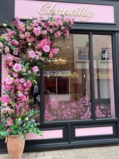 a flower shop with pink flowers in the window