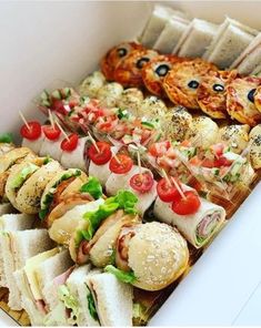 many different types of food are on display in a white box, with toothpicks sticking out of them