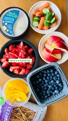 fruit, crackers and yogurt are arranged in bowls on a wooden table