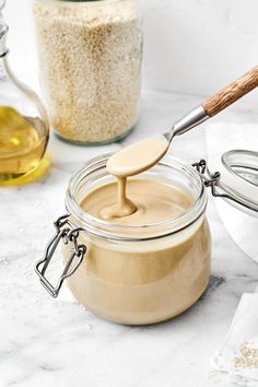 a spoon in a jar filled with peanut butter