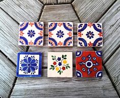 four different colored tiles sitting on top of a wooden table next to each other,