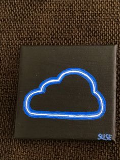 a black square with a blue cloud on it sitting on top of a brown carpet