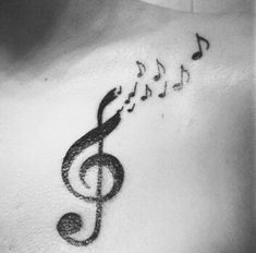 a man with musical notes on his chest and behind him is a treble tattoo