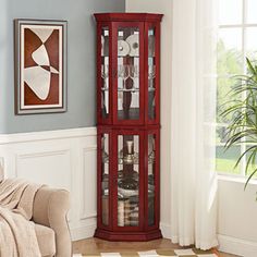 a tall red curio cabinet in a living room