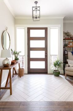 a living room filled with furniture and a wooden door in front of a white wall