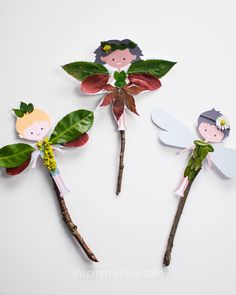 three little fairy wands made out of paper with leaves and flowers on them, sitting next to each other