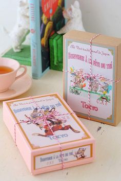 two books are sitting on a table next to a cup and saucer with tea in it