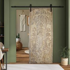 a living room with green walls and a white rug in front of a door that has an intricate design on it