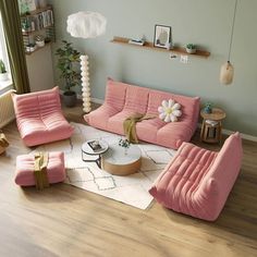 a living room with pink couches and white rugs on the wooden flooring