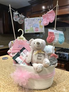 a white teddy bear sitting in a basket on top of a counter next to baby items