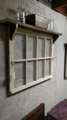 an old window is hung on the wall above a wooden table and bench in a small room