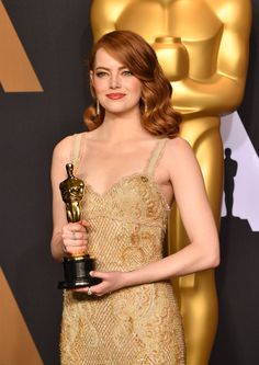 the actress is posing with her oscar award