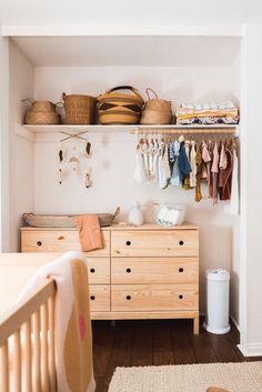 a baby's room with wooden furniture and baskets on the shelves, including a crib