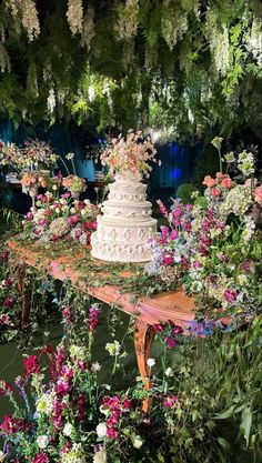 a wedding cake sitting on top of a table surrounded by flowers