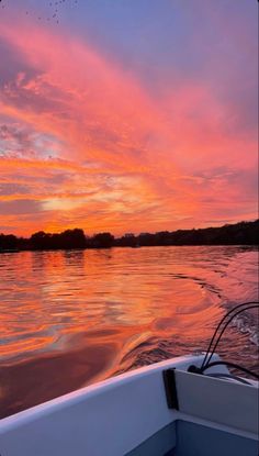 the sun is setting over the water as seen from a boat