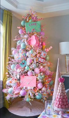 a pink christmas tree decorated with candy and lollipops