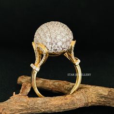 a diamond ring sitting on top of a piece of drift wood next to a twig