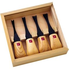 four wooden knives in a box on a white background