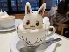 a white cup filled with marshmallows and topped with a small bunny face