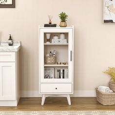 a white cabinet sitting next to a sink in a bathroom on top of a hard wood floor