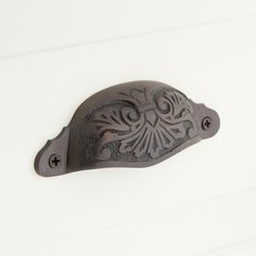 an ornate iron door handle on a white wall