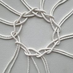 a close up view of the white thread on a piece of cloth with knots around it