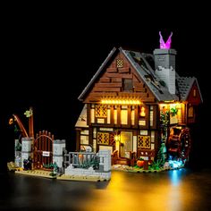 a lego lit up house with lights on it's roof and front porch, in the dark