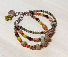 "I love the rustic bohemian vibes of this multistrand bracelet!  For this bracelet I have used a variety of Czech glass beads in various colors, aged Czech Picasso seed beads, and acrylic beads, along with antique copper accents, and rhinestone rondelles.  Bracelet closes with a lobster clasp, and has an extender chain finished with a copper tree of life charm, and a flower bead dangle.   Bracelet best fits a wrist size between 6-1/2\" - 7-1/4\".   If a longer extender is needed, please leave a Bohemian Multi-strand Bracelets, Bohemian Multi-strand Hand-strung Bracelets, Bohemian Multi-strand Adjustable Bracelets, Bohemian Multi-strand Bracelets For Beach, Handmade Bohemian Multi-strand Bracelets, Handmade Multi-strand Bracelets For Festival, Handmade Multi-strand Festival Bracelets, Bohemian Brown Bracelets, Bohemian Brown Bracelets For Festival