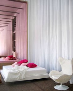 a bedroom with pink walls and white furniture