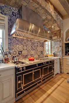 a large kitchen with an oven, stove and counter top in the middle of it