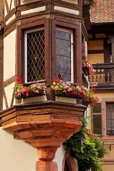 an old building with flowers in the window boxes