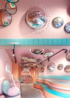 there are many circular mirrors on the wall in this room with pink walls and blue trim