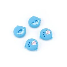 three blue buttons with white teeth and one has a shark on the front, while four are